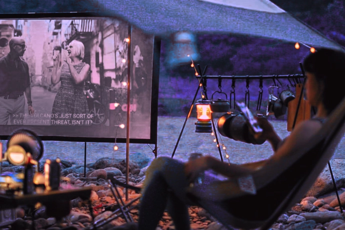 Un couple organise une séance de cinéma en pleine nature