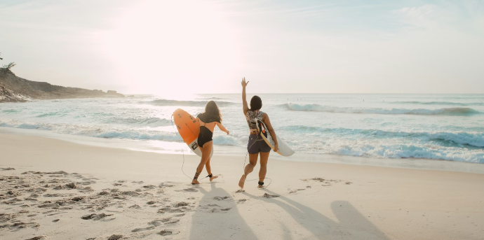 Un couple fait un cours de sur sur la plage de Pors Carn