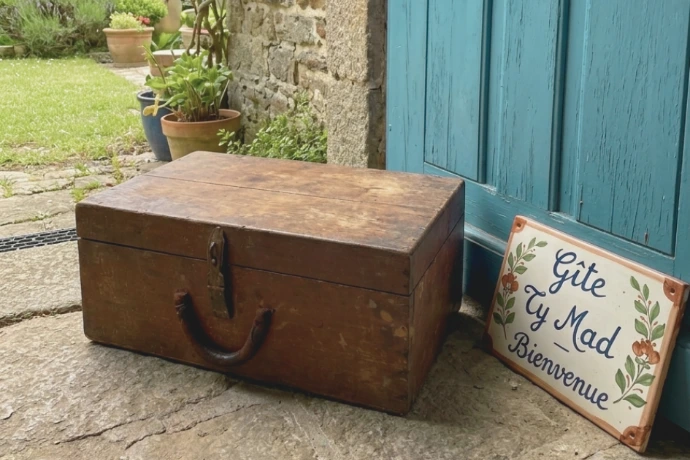 Une malle en bois devant un gîte en Bretagne